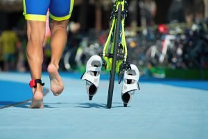 Triathlet mit rennt mit Fahrrad in Wechselzone