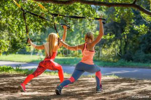 zwei frauen bei sling training in wald