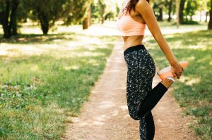 frau bei stretching der beine im park 