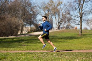 Mann joggt im Park und treibt Cardio-Training