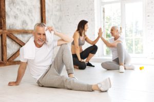 Altes Paar nach Pilates/Yoga Training mit junger Trainerin.