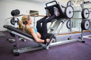 frau beim training an einer beinpresse im fitnessstudio