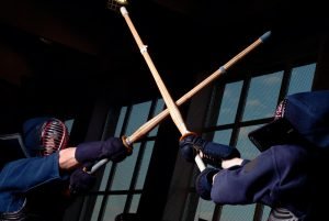 zwei kendo kampfsportler kämpfen mit stöcken