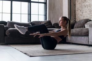 frau macht crunches im wohnzimmer