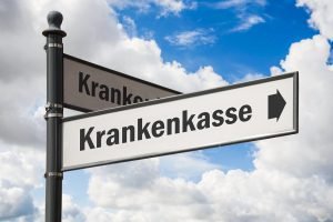 zwei straßenschilder richtung krankenkasse