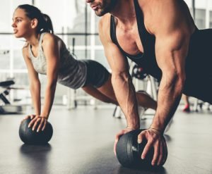 frau und mann beim plank mit gymnastikball