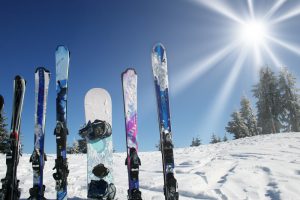 mehrere paar ski und snowboard im schnee