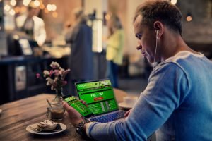 mann platziert online sportwetten in cafe