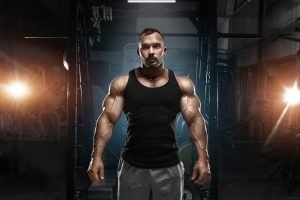 Mann mit massiven Muskeln in Fitnessstudio