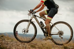 Mann fährt mit Mountainbike bergauf durch Matsch