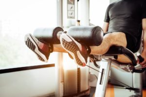 Mann trainiert an der Beinpresse im Fitness Studio