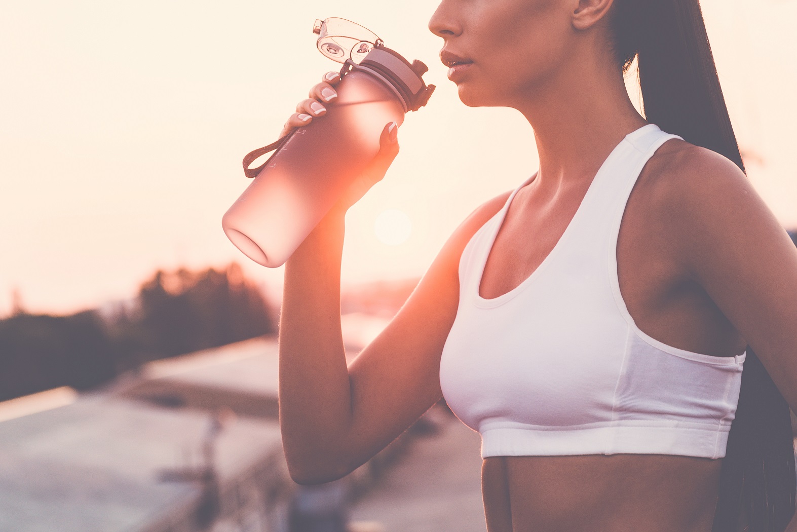 frau trinkt beim sport auf wasserflasche