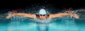 Fitness und Muskeln aufbauen durch Schwimmen: Mann beim Delphinschwimmen