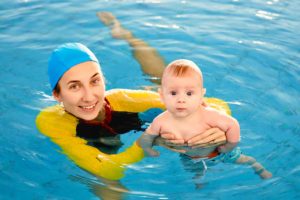 frau mit einem baby im schwimmbad