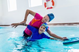 ein kind lernt die kraulbewegung beim schwimmen kennen