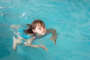 ein kleines maedchen beim schwimmen lernen